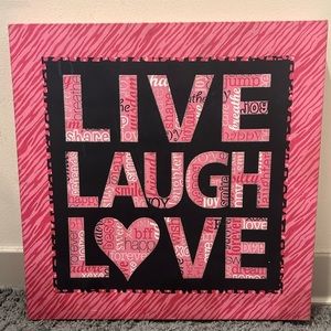 Pink and black canvas with pink and white words of LIVE, LAUGH, LOVE